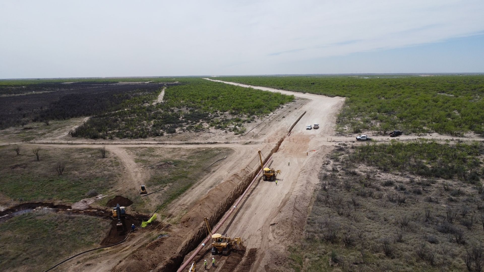 An aerial view of a dirt road in the middle of a field.