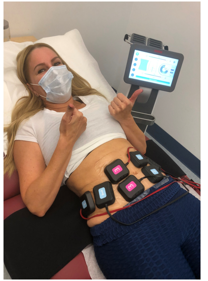 A woman wearing a mask is laying in a hospital bed