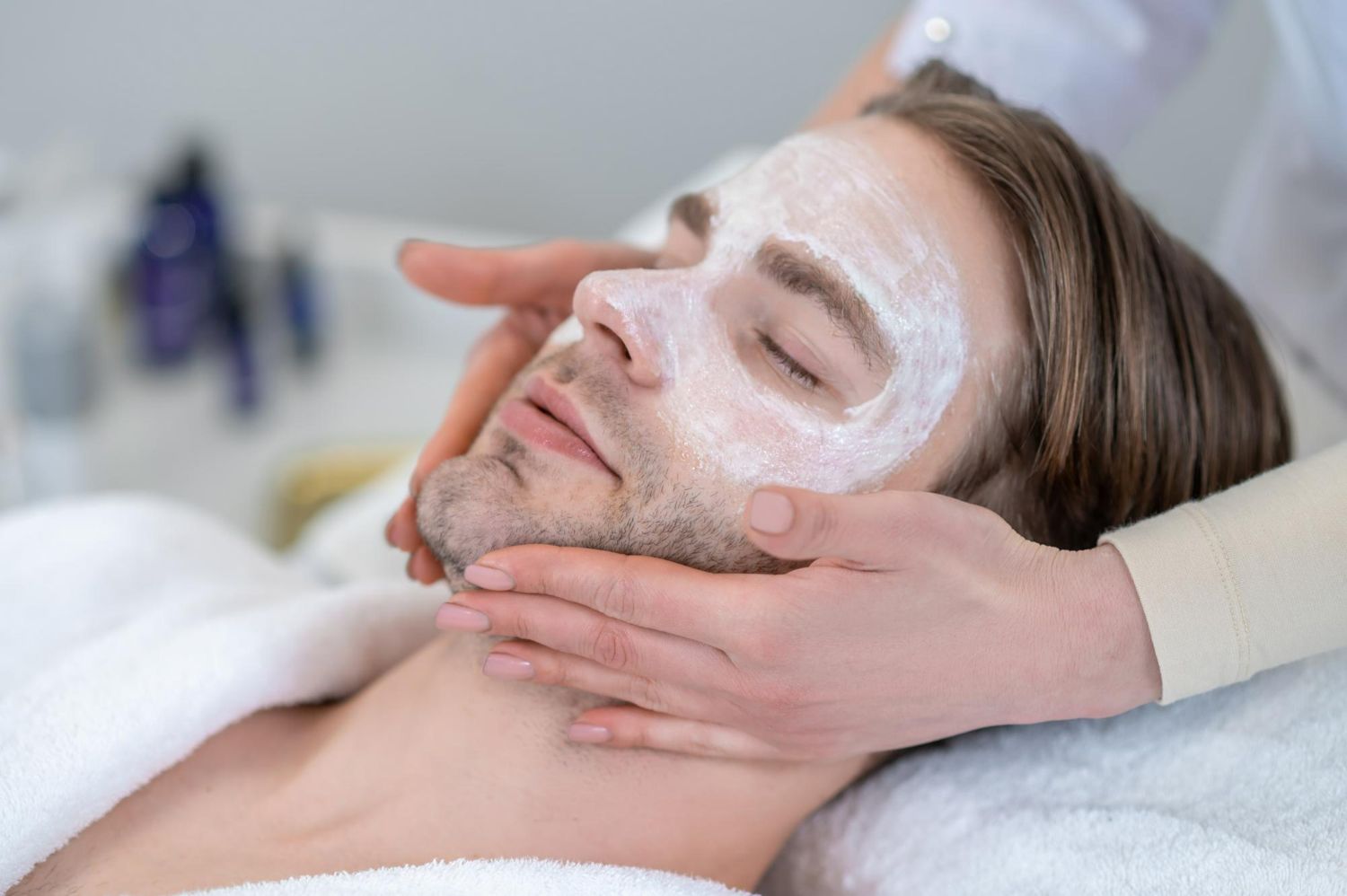 A man is getting a facial treatment at a spa.