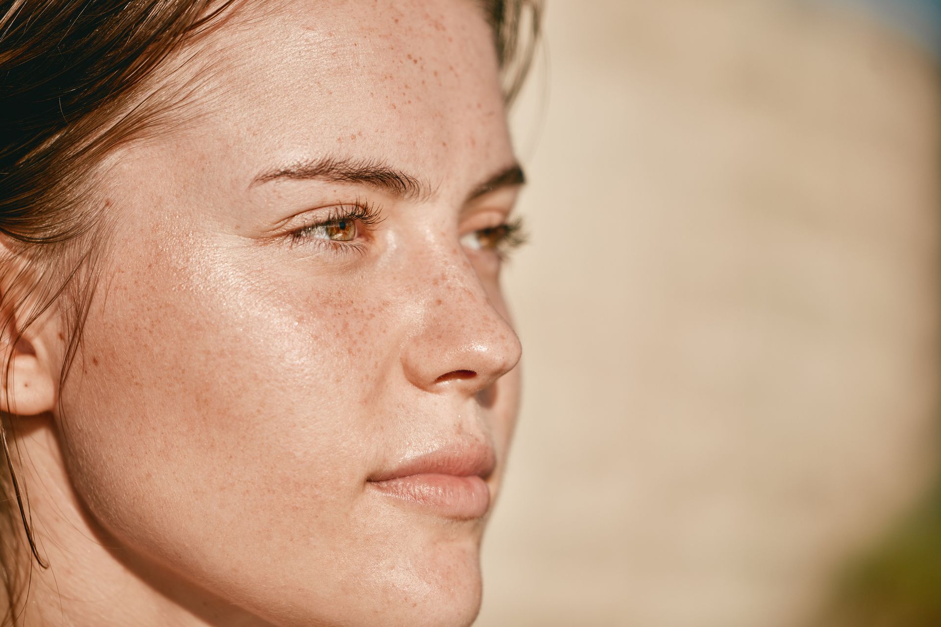 A close up of a woman 's face with a lot of freckles.