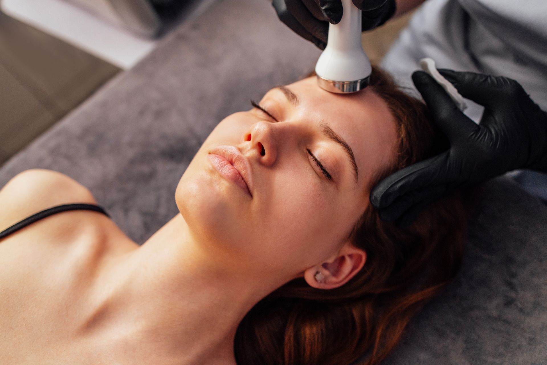 A woman is getting a facial treatment at a beauty salon.