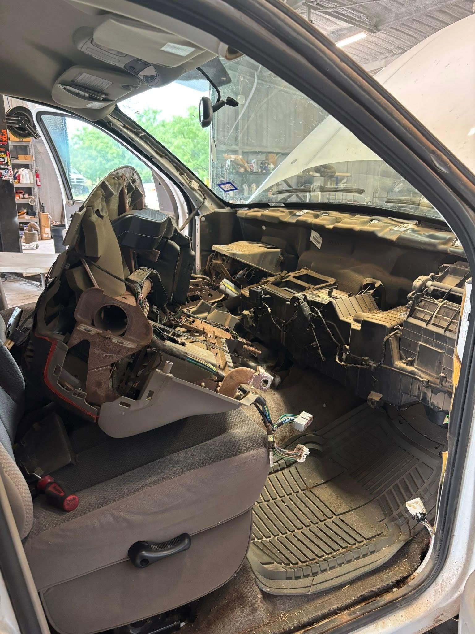 Interior of a vehicle with dashboard components removed, revealing wires and parts.
