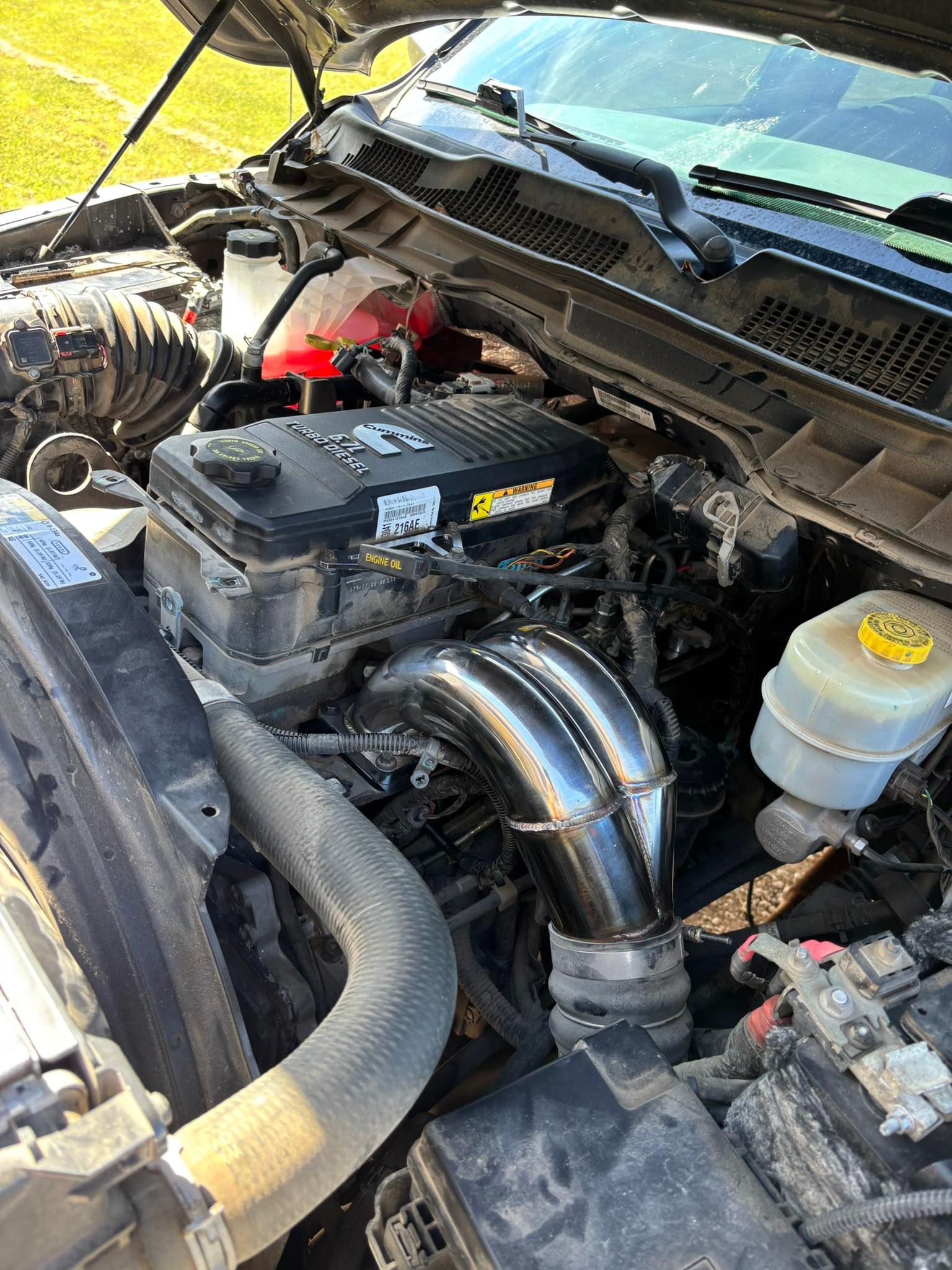 Close-up of a diesel truck engine compartment, featuring shiny metal intake and various components.
