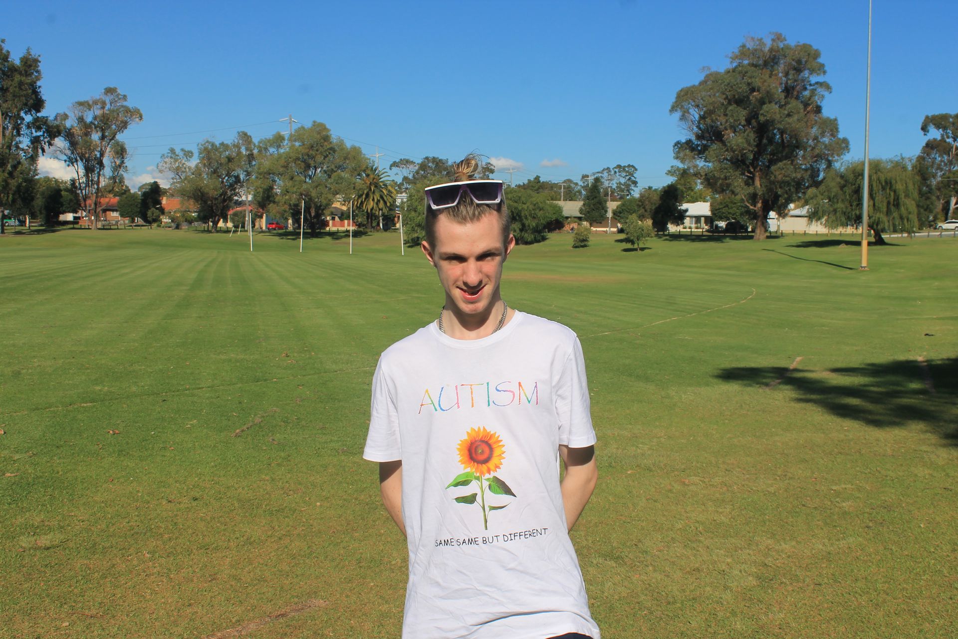 A man wearing a white shirt with a sunflower on it