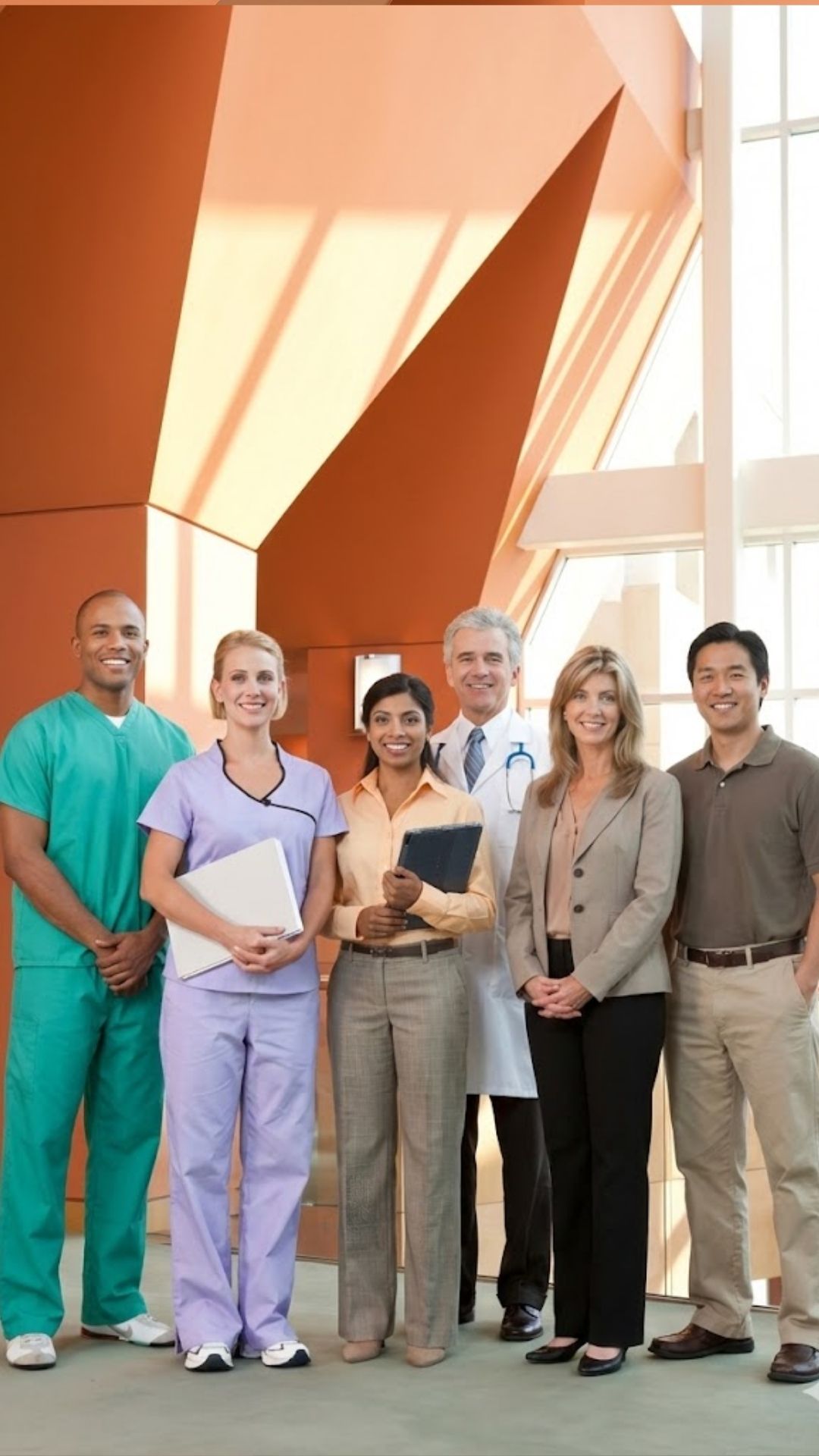 A diverse, smiling team of NDIS Support Coordinators, discharge planners, and hospital clinicians collaborating in a modern facility to ensure a seamless transition of care and effective hospital discharge for Plan and Grow participants.