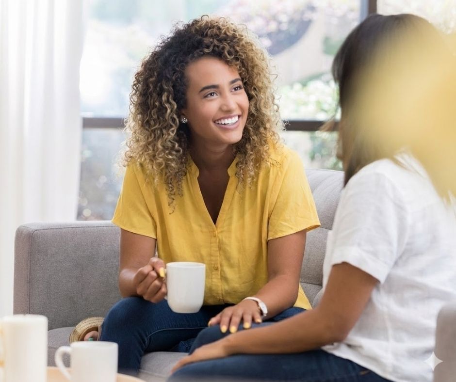 An NDIS specialist and participant engaging in a calm, supportive conversation in a bright Australian living room, representing the use of specialist behavioural strategies to ensure emotional stability and psychological wellbeing within a safe, stable home.