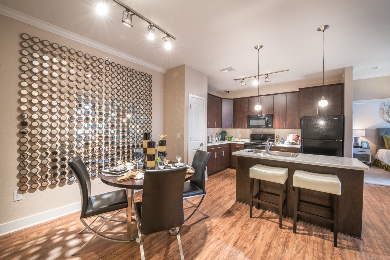 Open-concept kitchen and dining area with an island, dark wood cabinets, and circular wall decor.