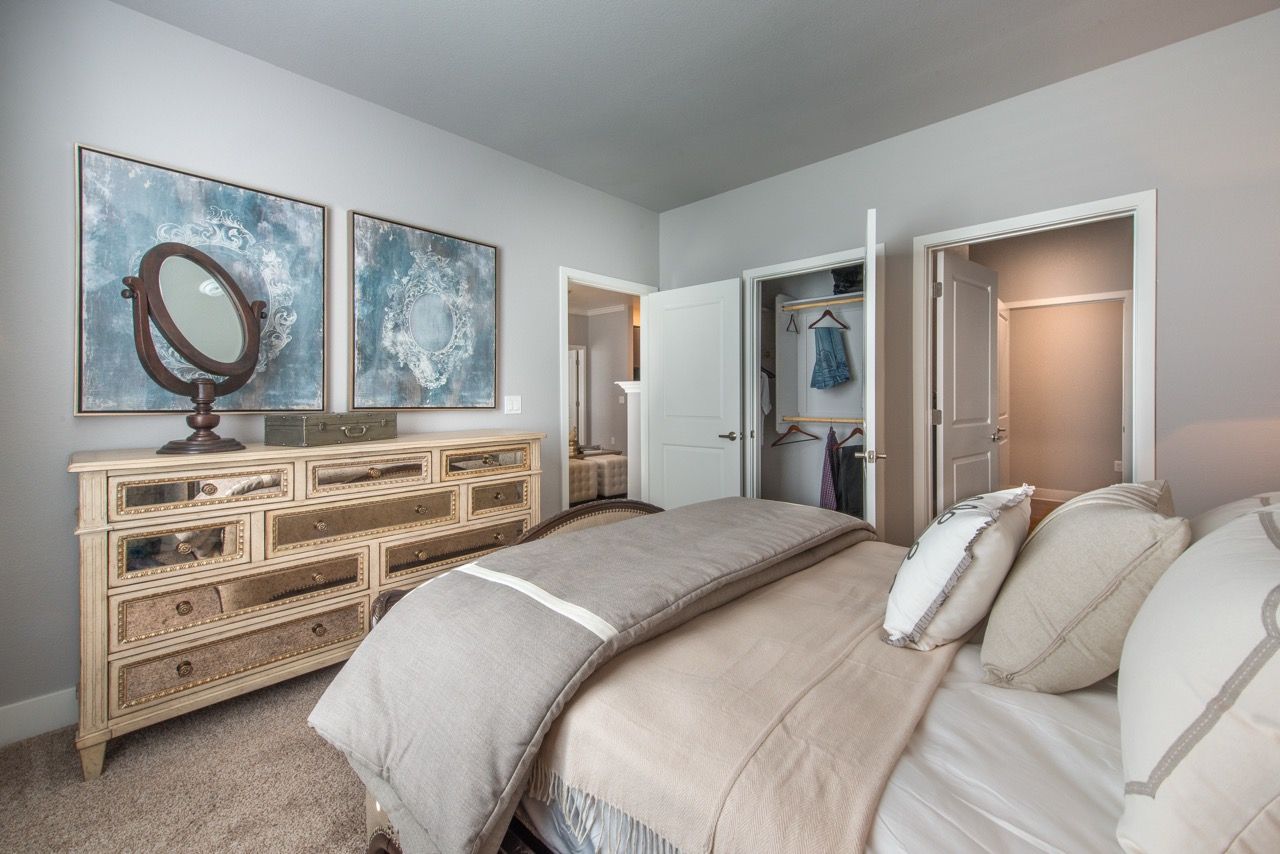 Bedroom with a large decorative dresser, two blue-toned wall art pieces, and an open closet.