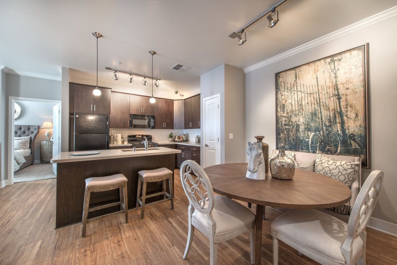 Open-concept kitchen with dark cabinetry, island, and a round dining table.