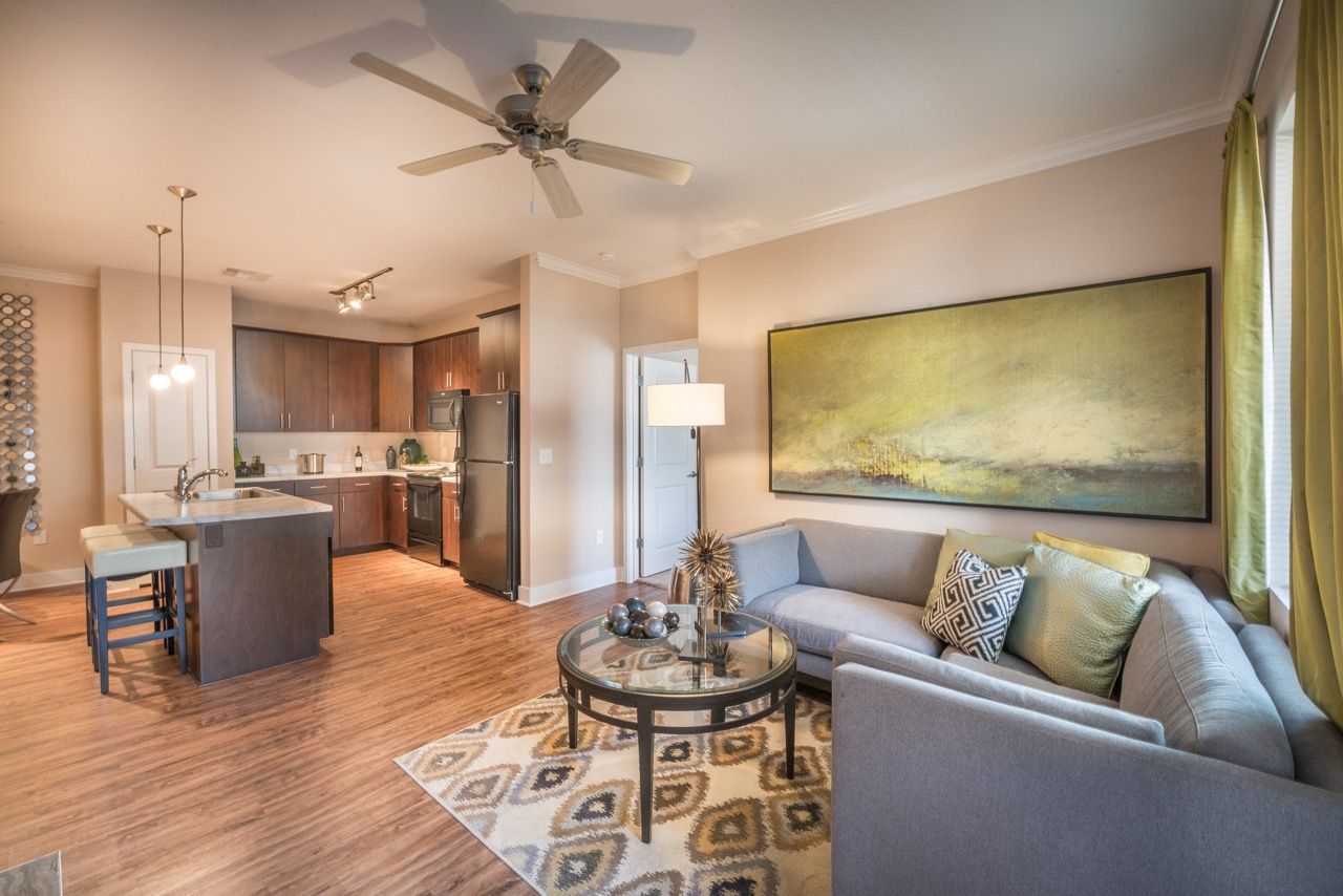 Open-concept living room with kitchen island, sofa, and artwork.
