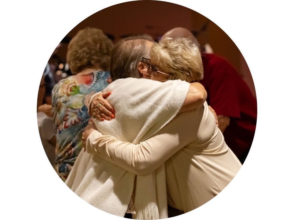 A group of people are sitting around a picnic table.