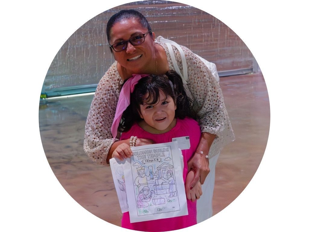 A group of people are sitting in a lecture hall raising their hands to answer a question.