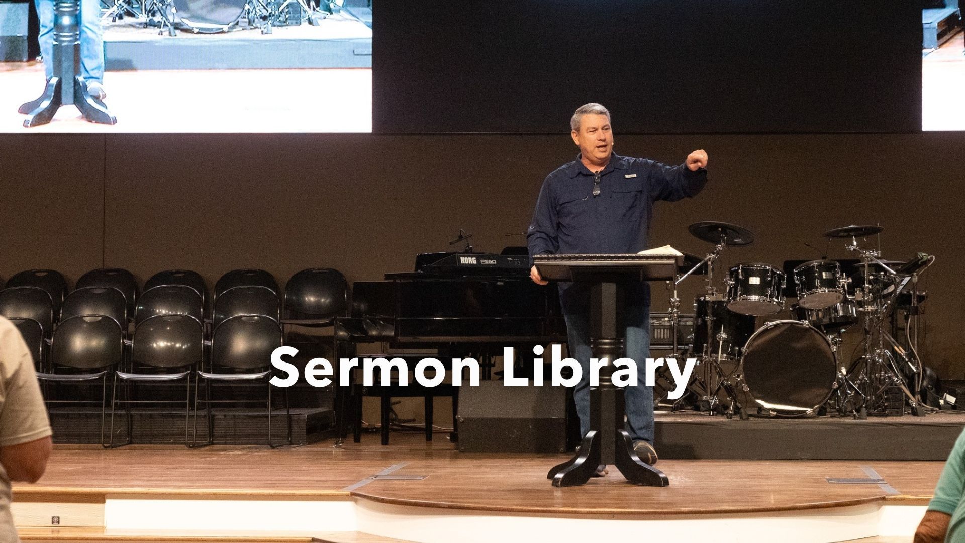 A man is standing at a podium giving a sermon in a church.