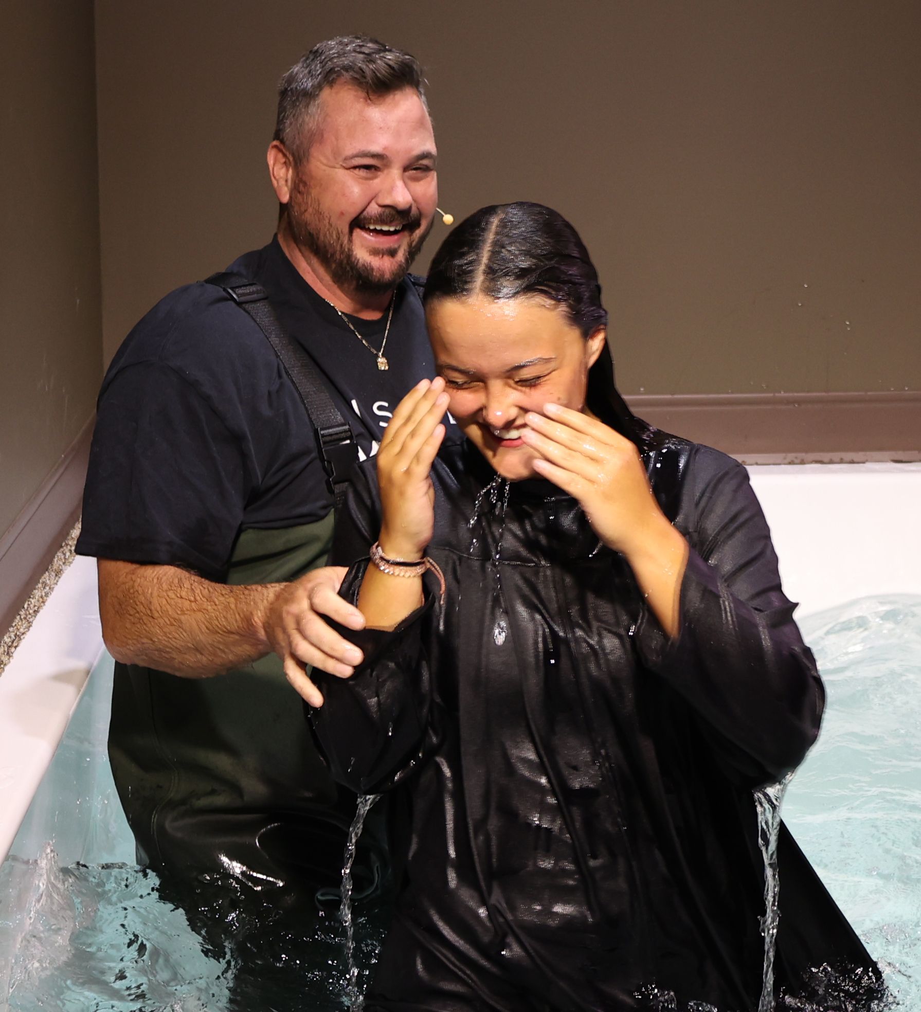 A man is standing next to a woman in a bathtub
