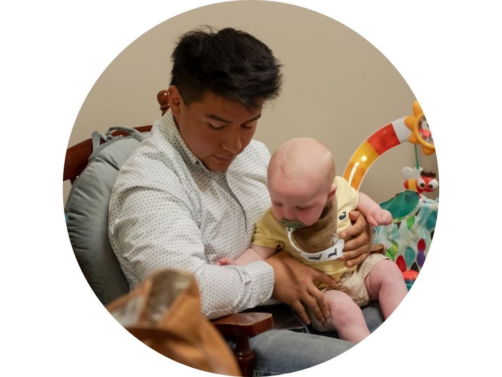 A woman is sitting in a chair holding two children.