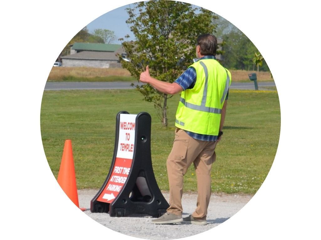 A man in a yellow shirt is walking through a parking lot
