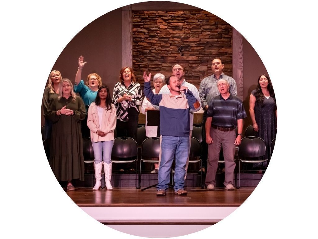 A group of people are standing in front of a large screen in a church.