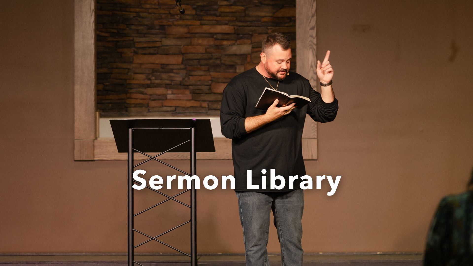 A man is standing at a podium giving a sermon in a church.