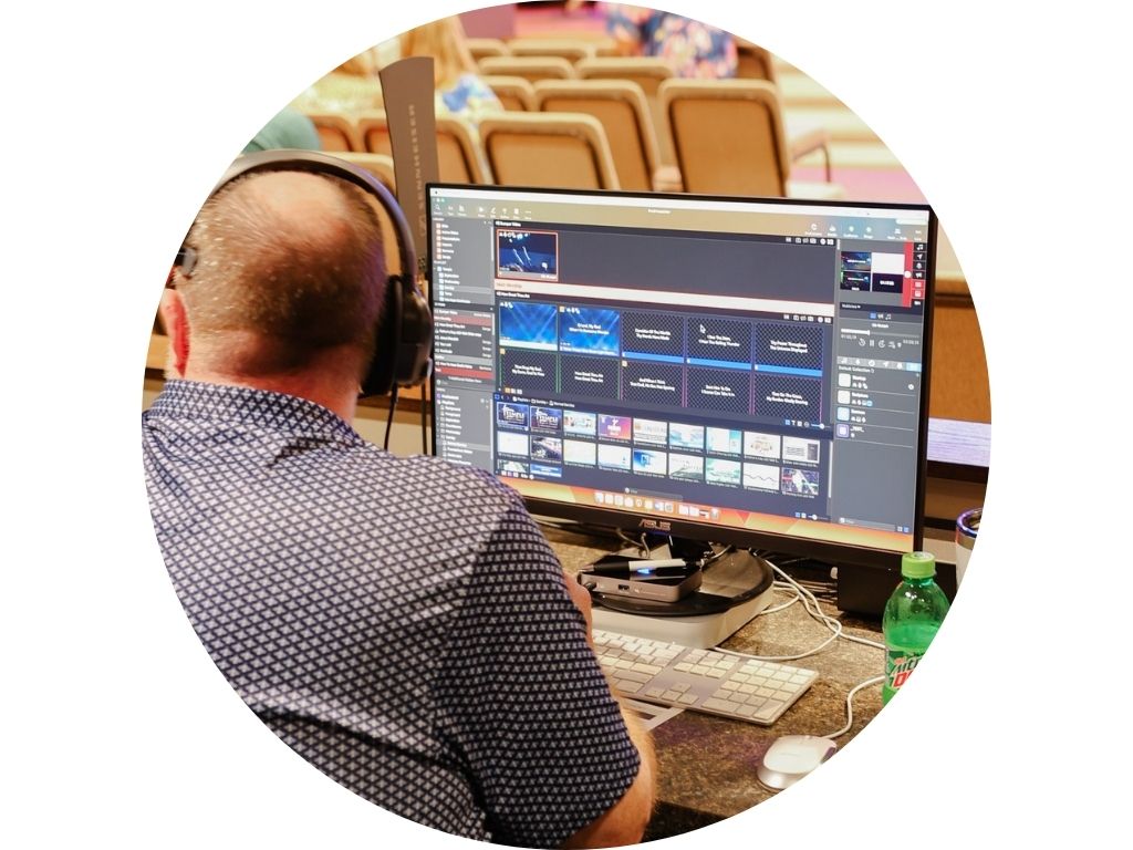 A man is sitting at a mixer in front of a crowd of people