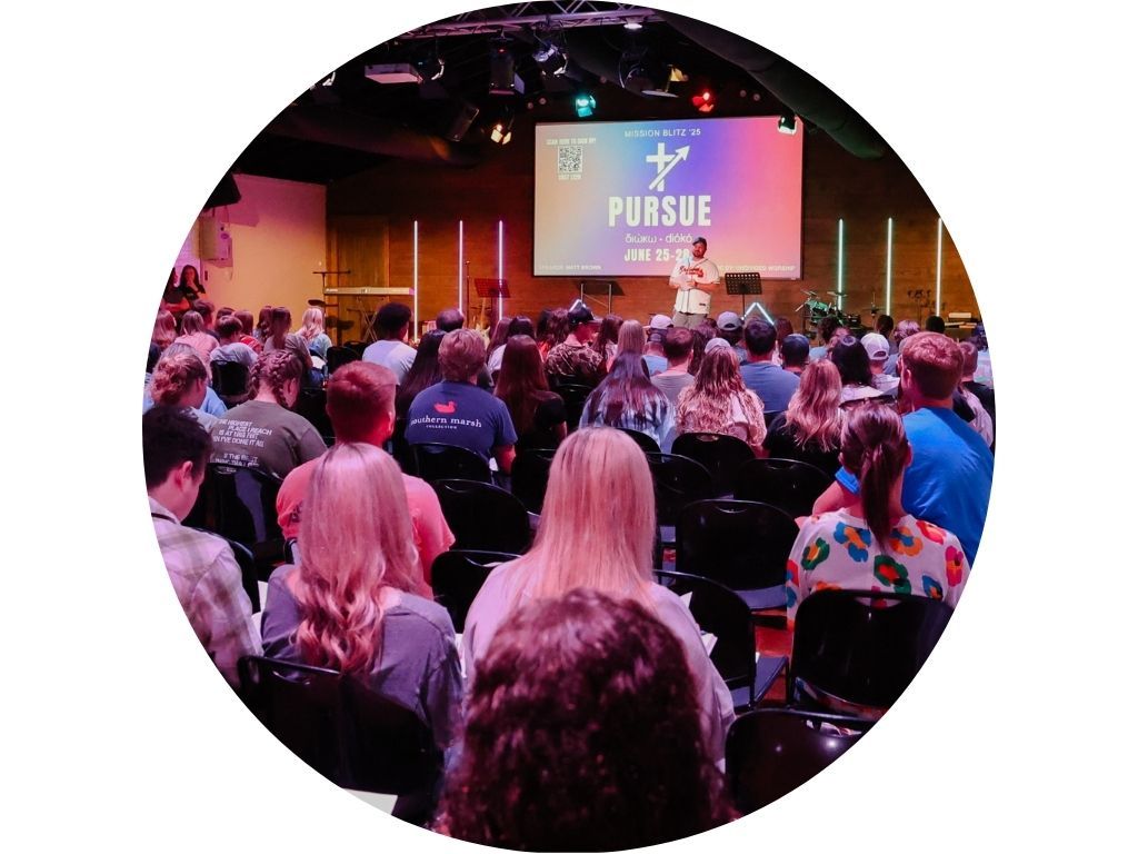 A group of people are sitting in a circle in an auditorium.