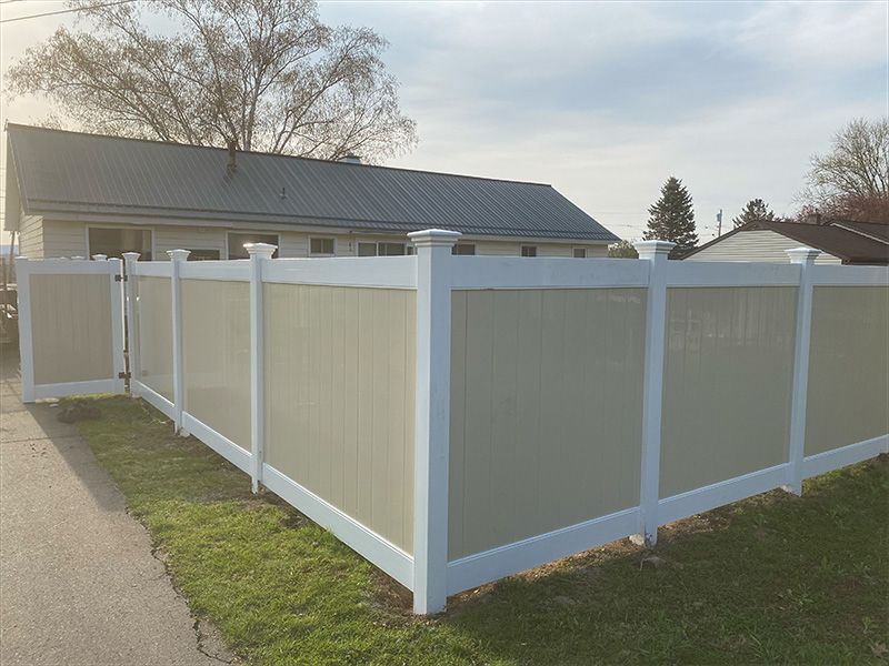 A white fence is sitting in front of a house.