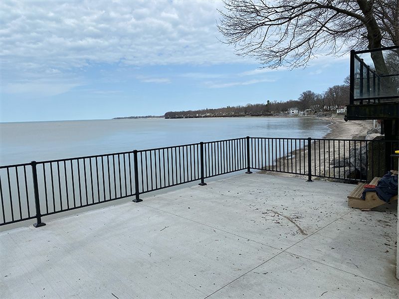 A deck with a railing overlooking a body of water
