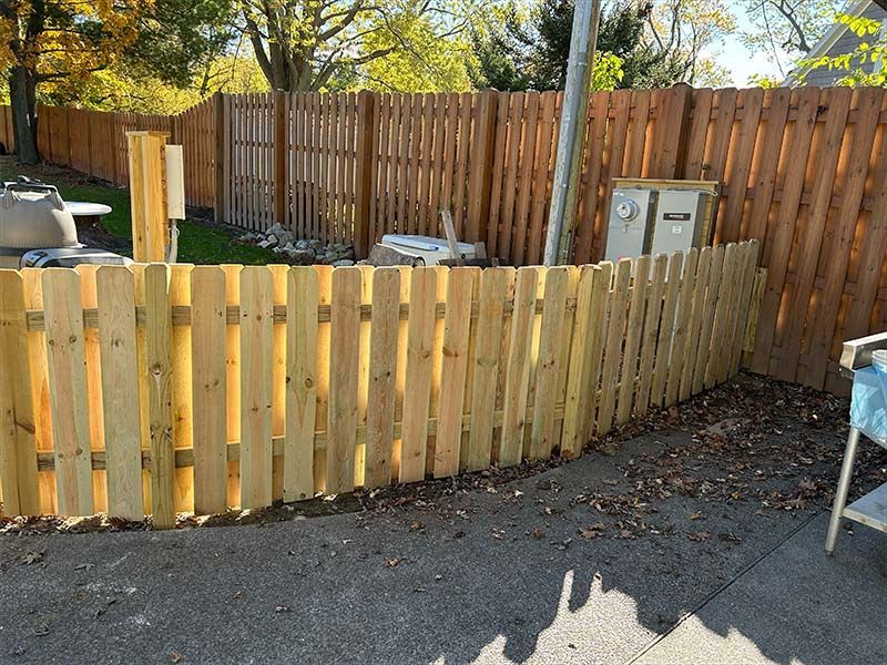 A wooden fence is being built in a backyard.