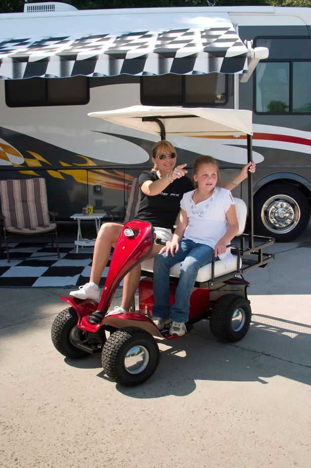 A man and a girl are sitting on a golf cart