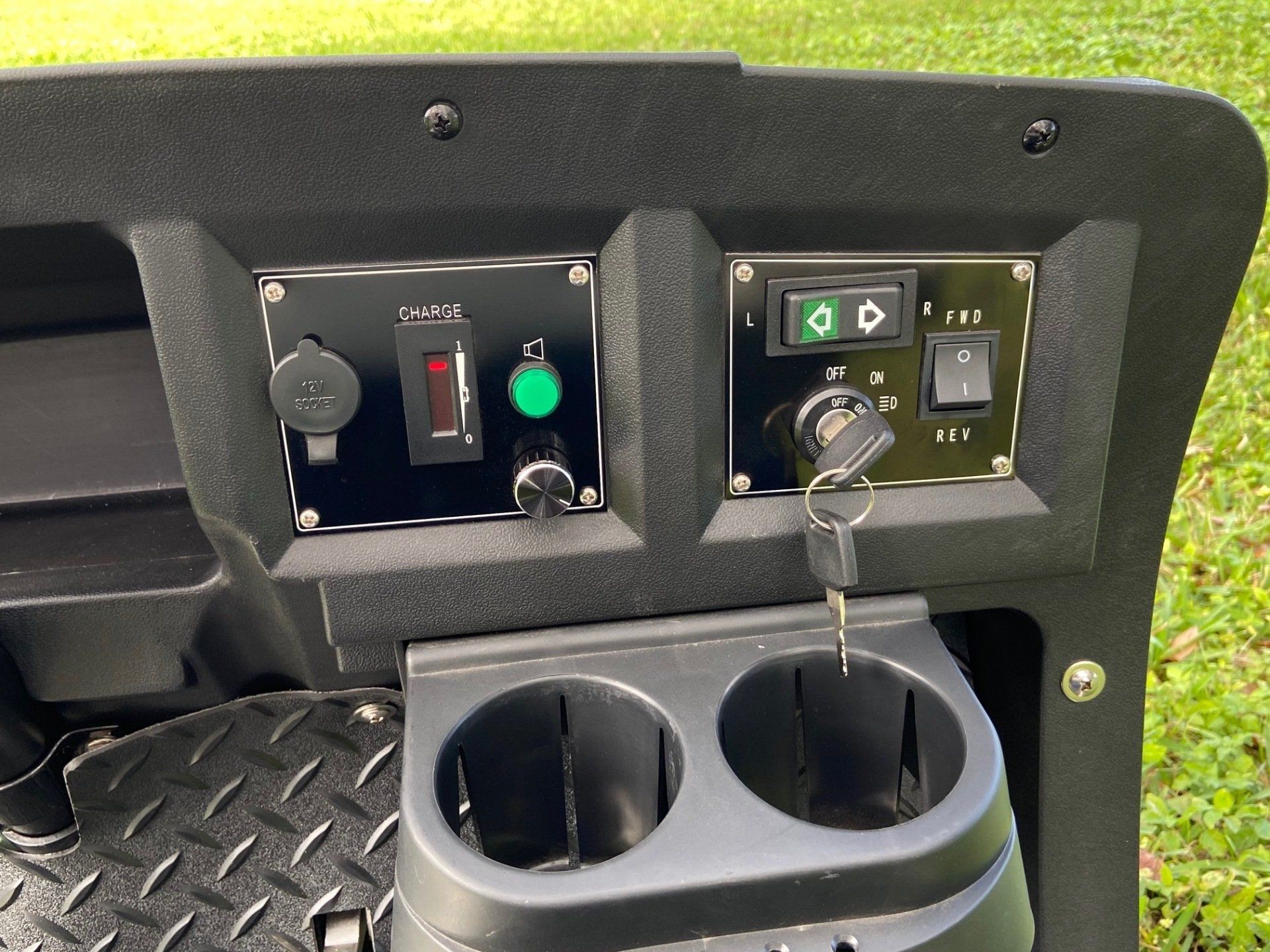 The dashboard of a golf cart with two cup holders