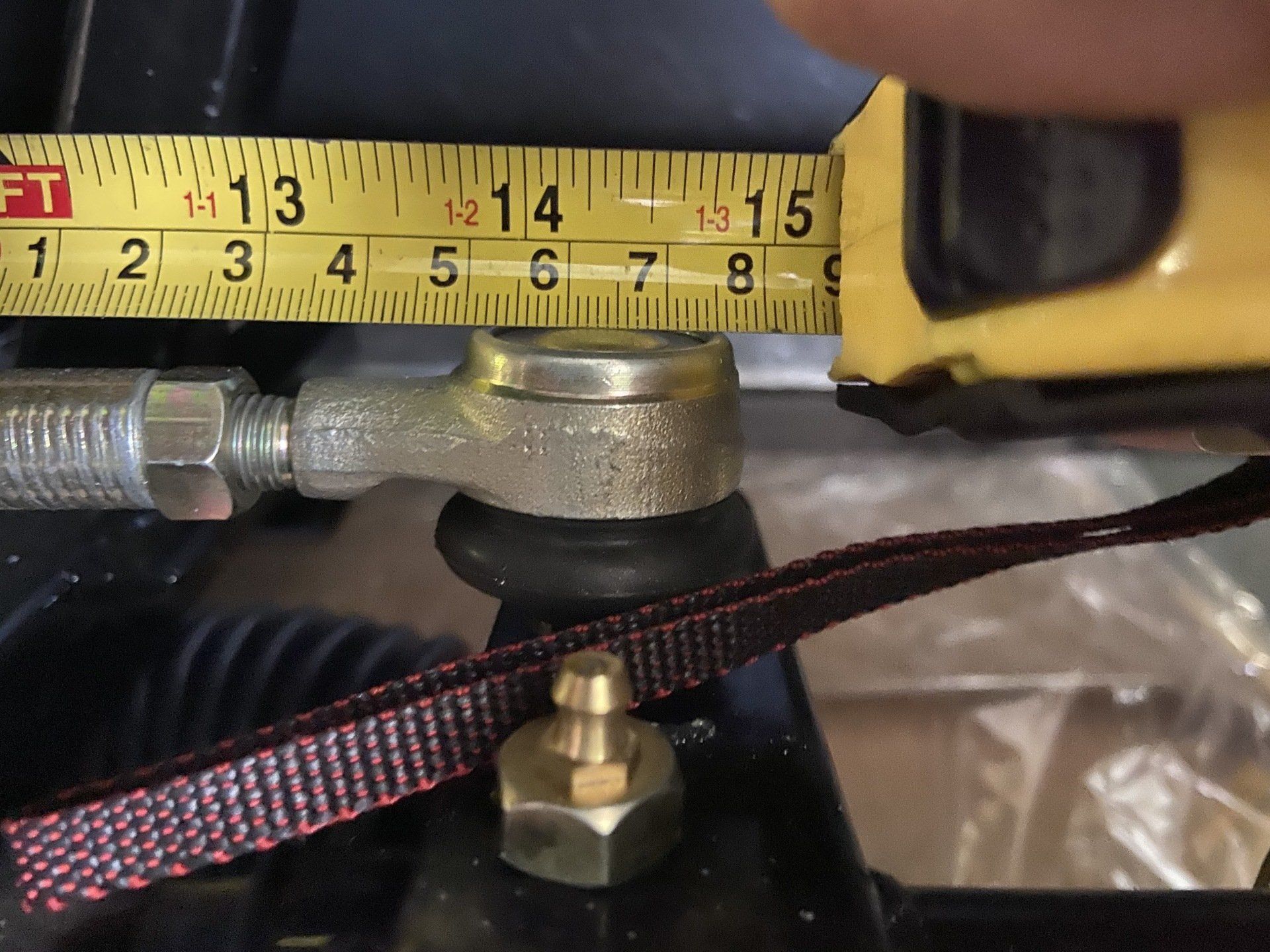 A person is measuring a piece of metal with a tape measure