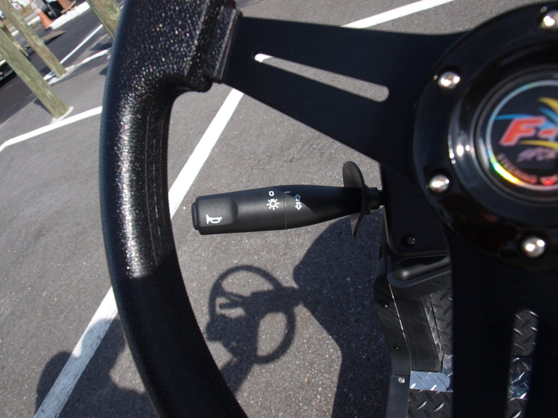 A black steering wheel with the letter f on it