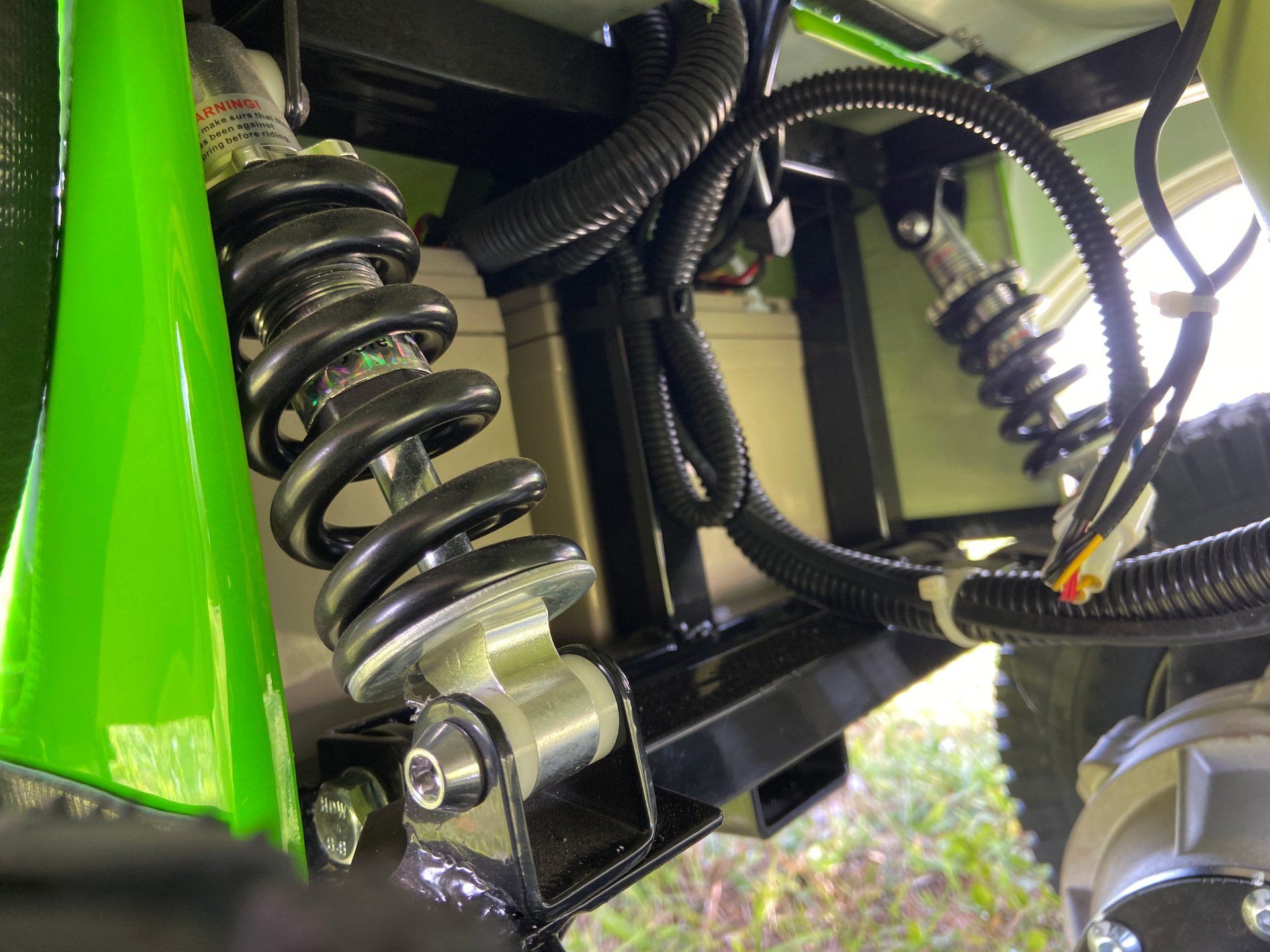 A close up of a shock absorber on a green vehicle