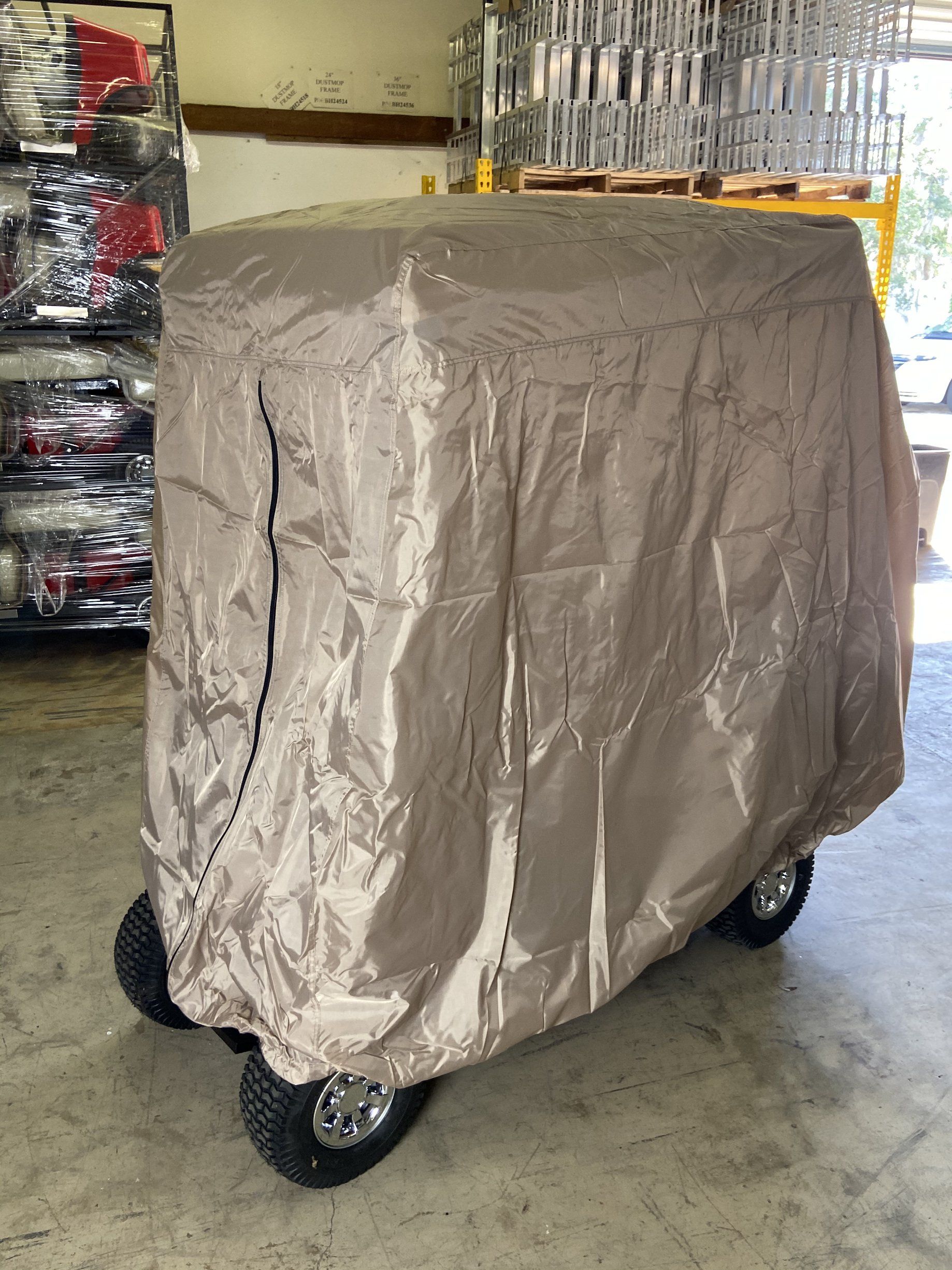 A golf cart with a cover on it is sitting in a garage.