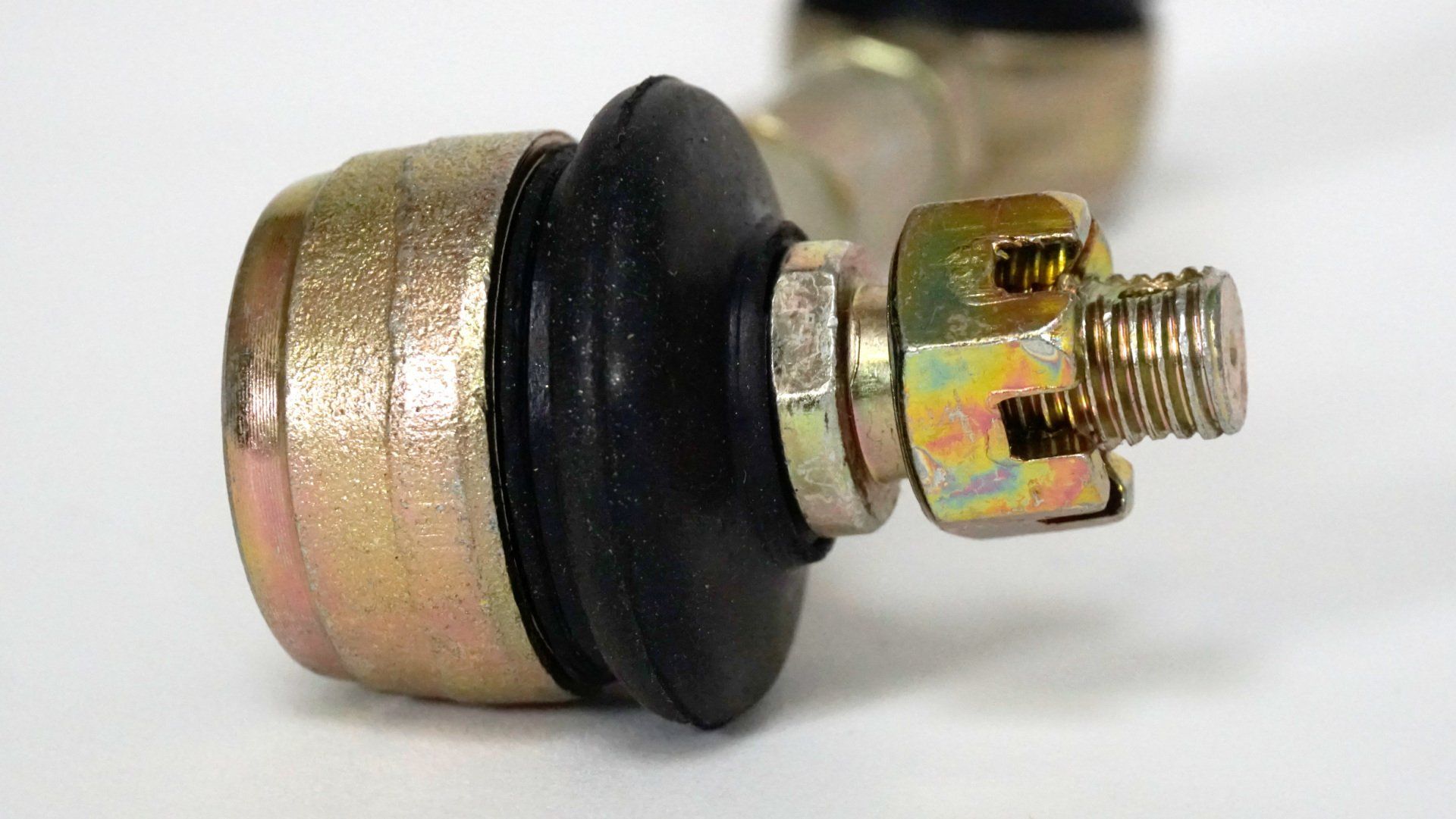 A close up of a metal part on a white surface.