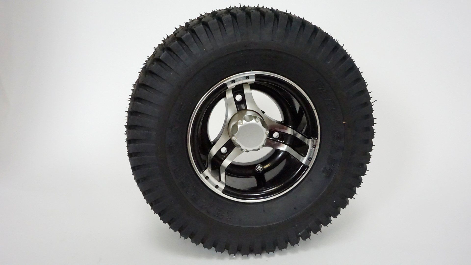 A close up of a tire and wheel on a white surface