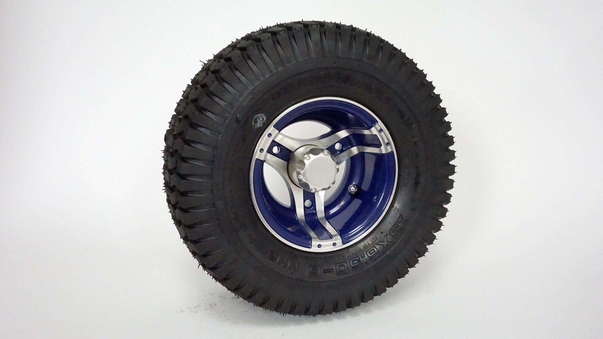 A tire with a blue rim is sitting on a white surface.