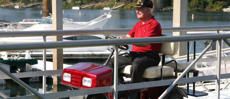 A man in a red shirt is sitting on a golf cart.
