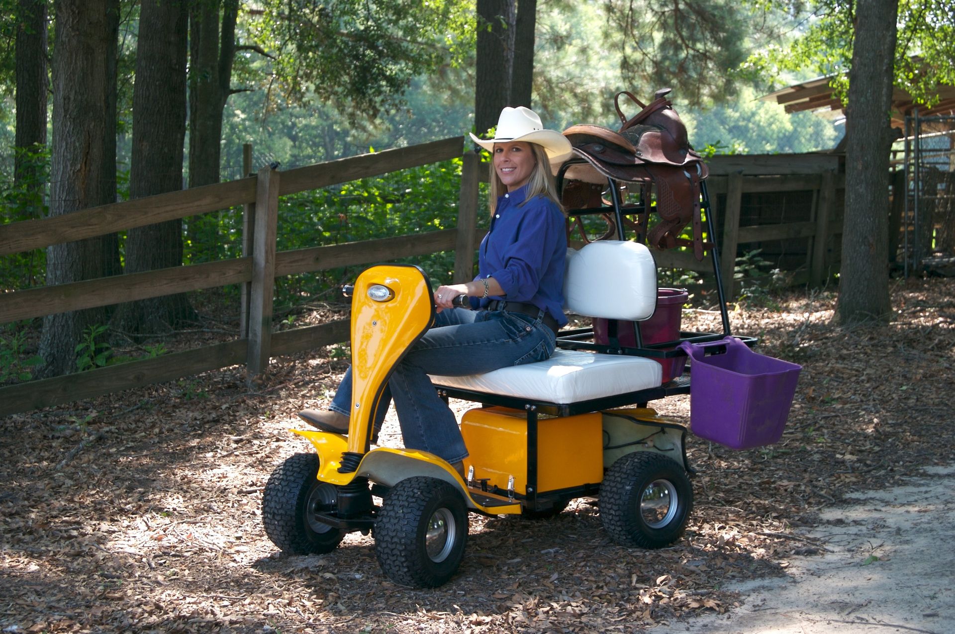 A woman in a cowboy hat is riding a yellow scooter
