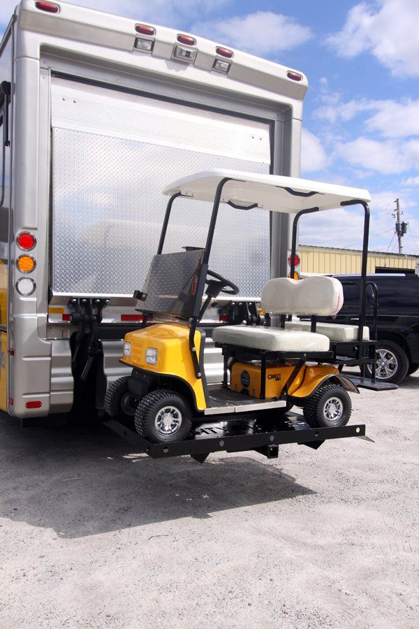 A golf cart is attached to the back of a truck