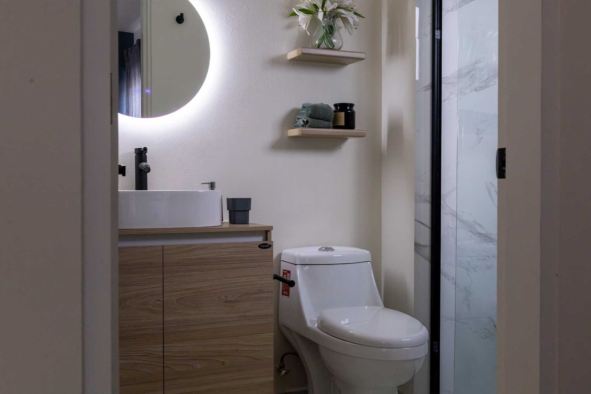 Un baño con inodoro, lavabo y espejo.