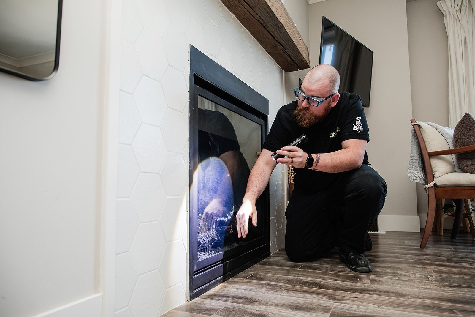 A man is kneeling down in front of a fireplace in a living room.