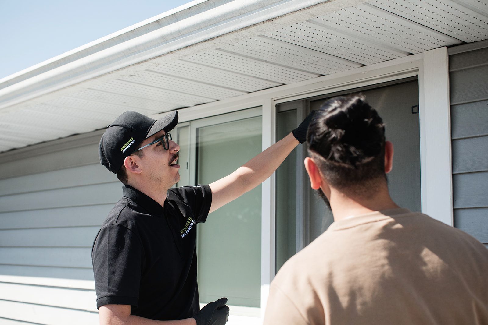 A man is talking to another man in front of a house.