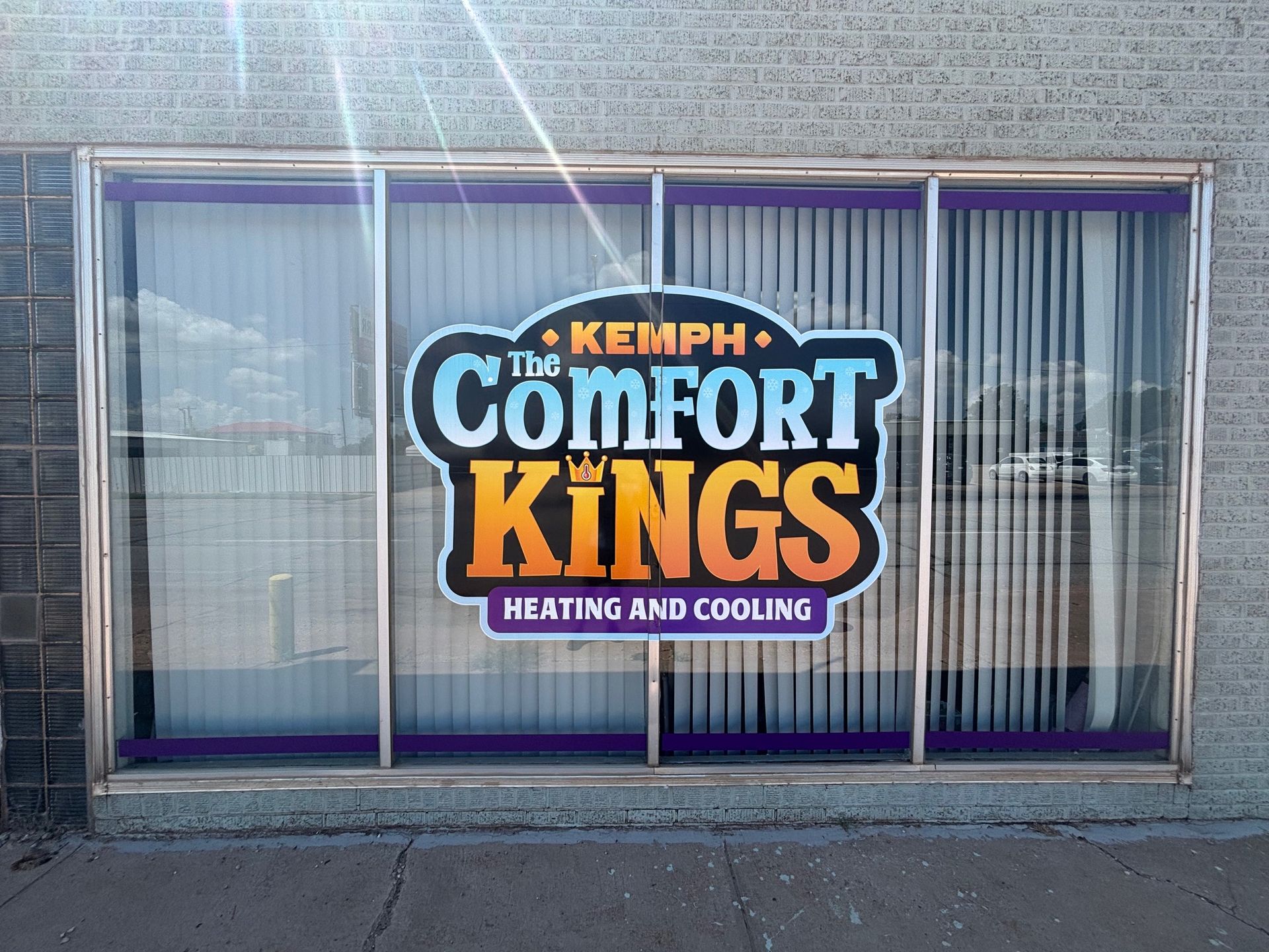 Kempf Comfort Kings sign on a building window. Features bold, colorful logo: