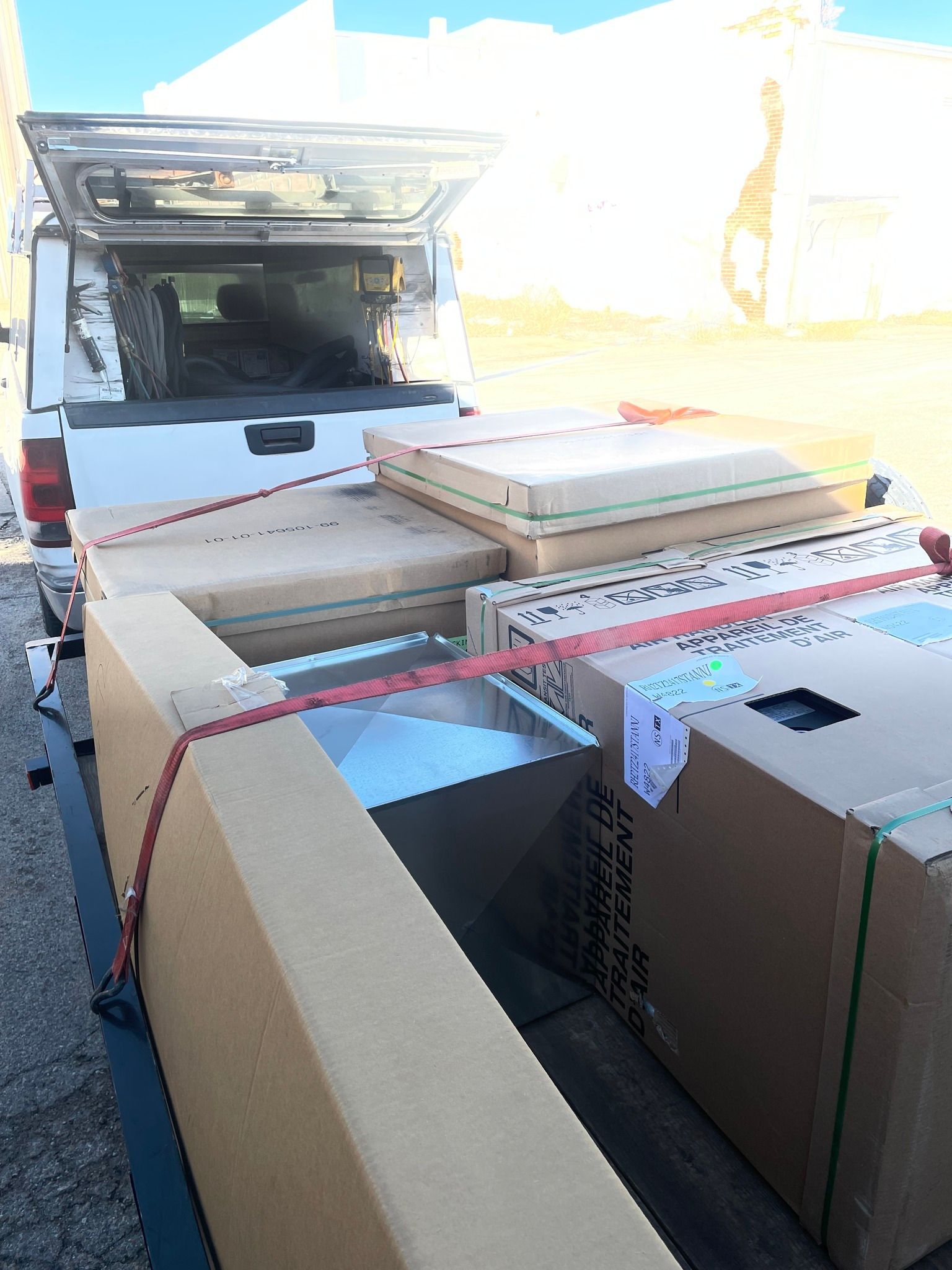 Truck bed loaded with boxes secured by straps.