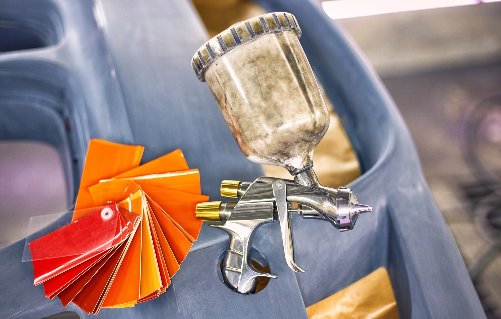 Persona con tuta protettiva che vernicia un'auto