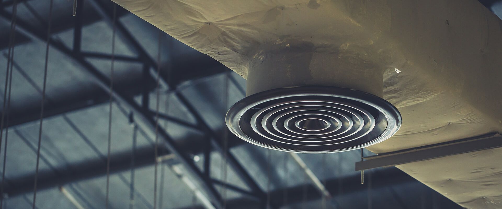 A close up of an air vent on the ceiling of a building.