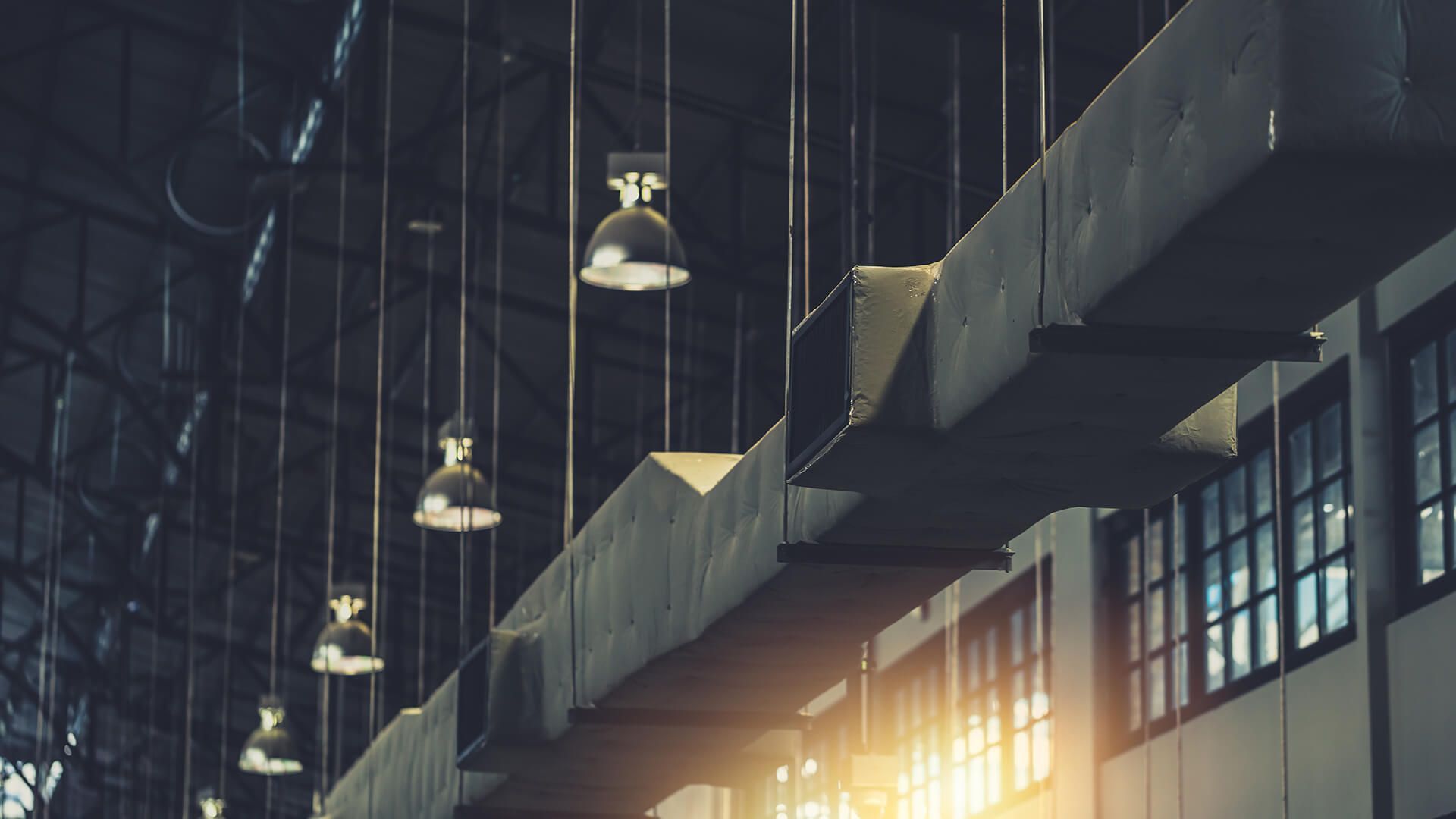 There are a lot of lights hanging from the ceiling of a building.