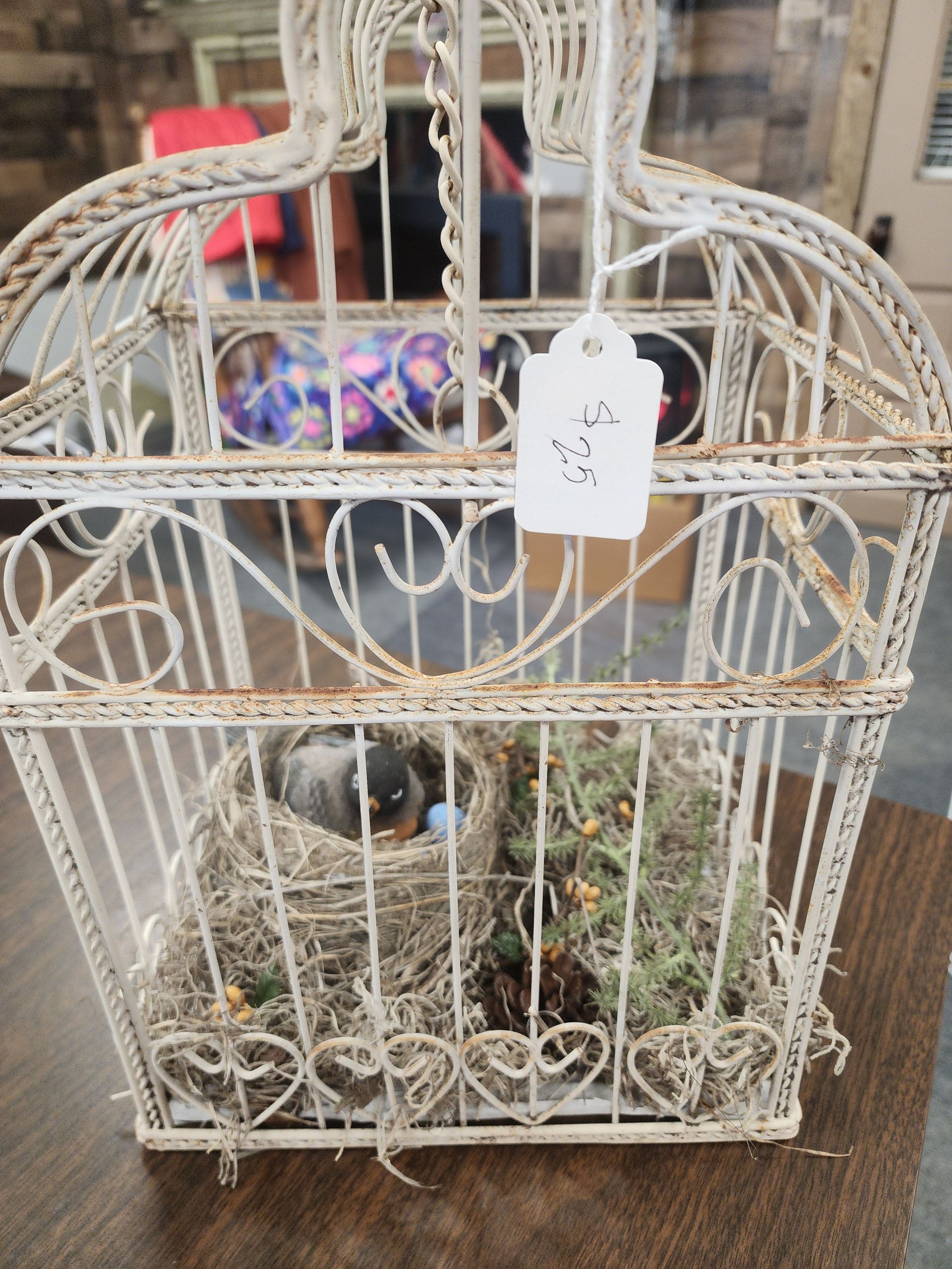 A bird cage with a tag attached to it