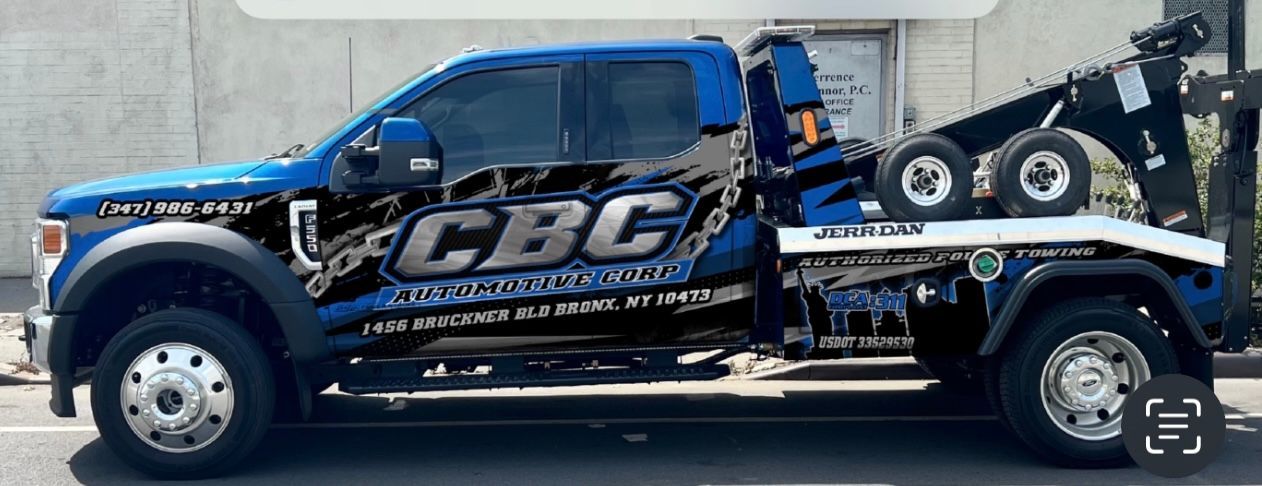 A blue tow truck is parked in front of a building.