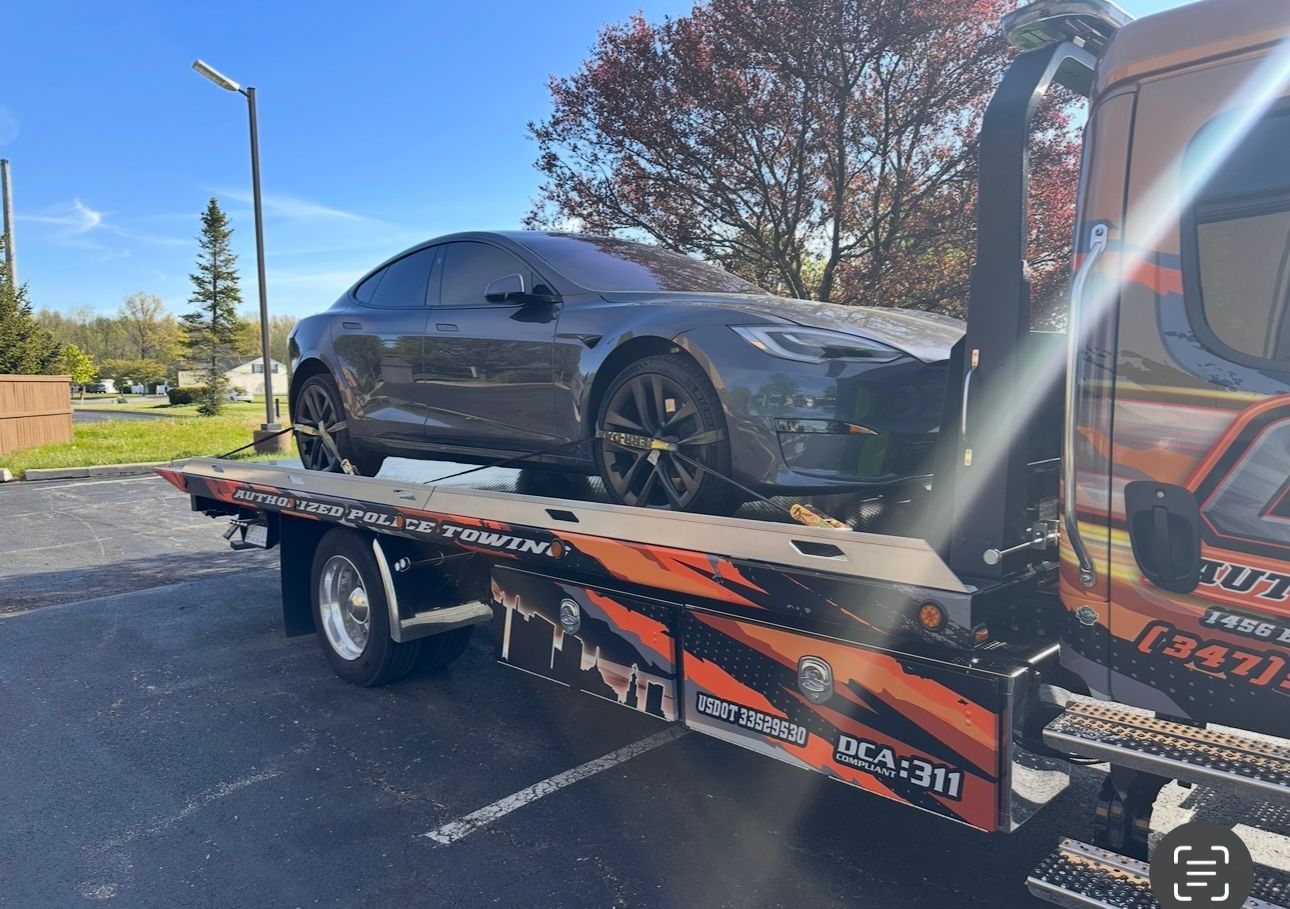 A car is being towed by a tow truck.